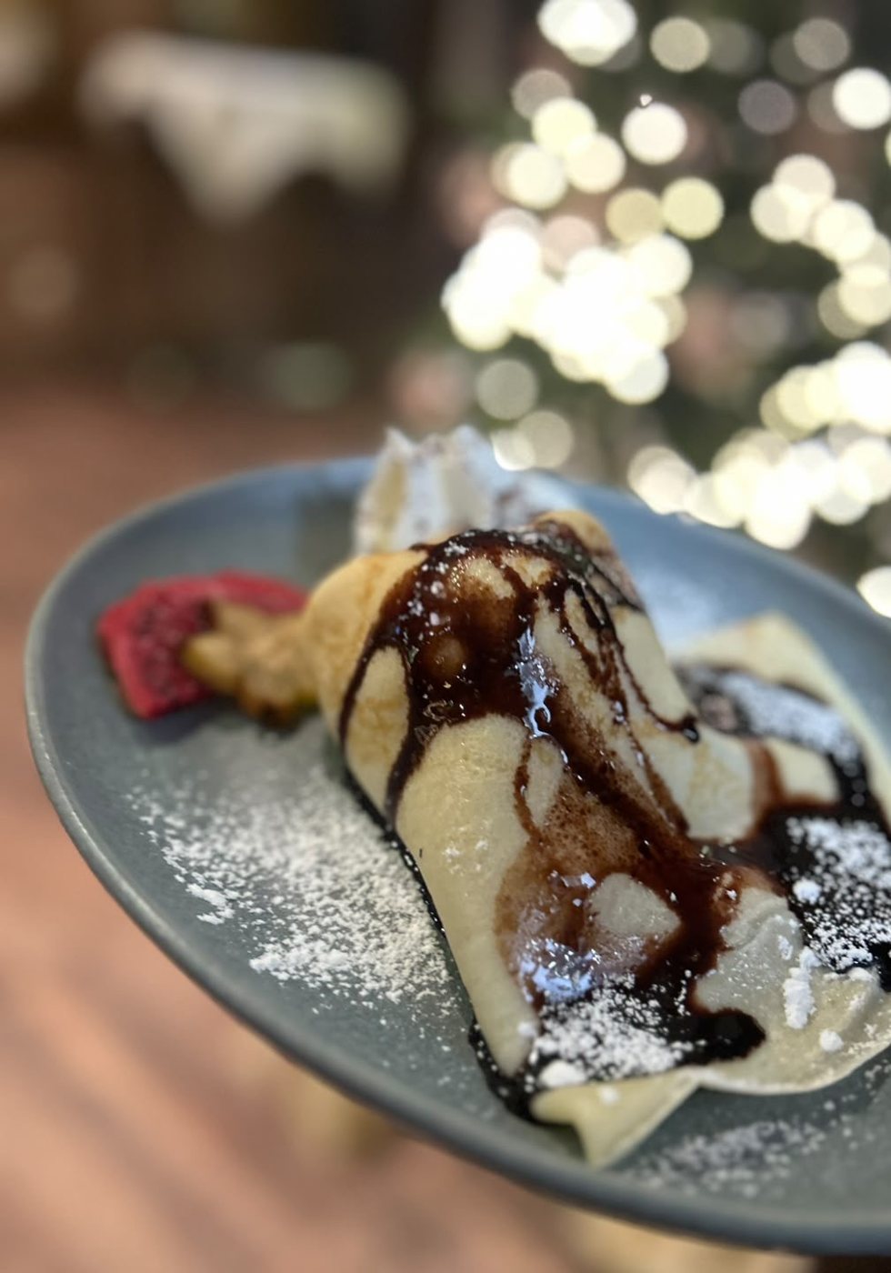 Gefüllter Pfannkuchen mit Schokosoße und Puderzucker