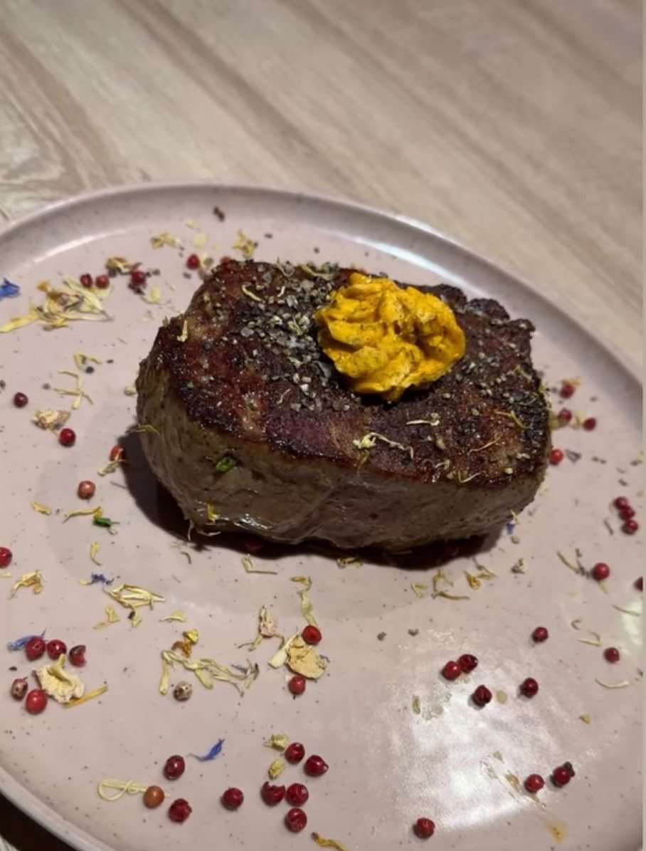 Steak mit Kräuterbutter, angerichtet auf hellem Teller