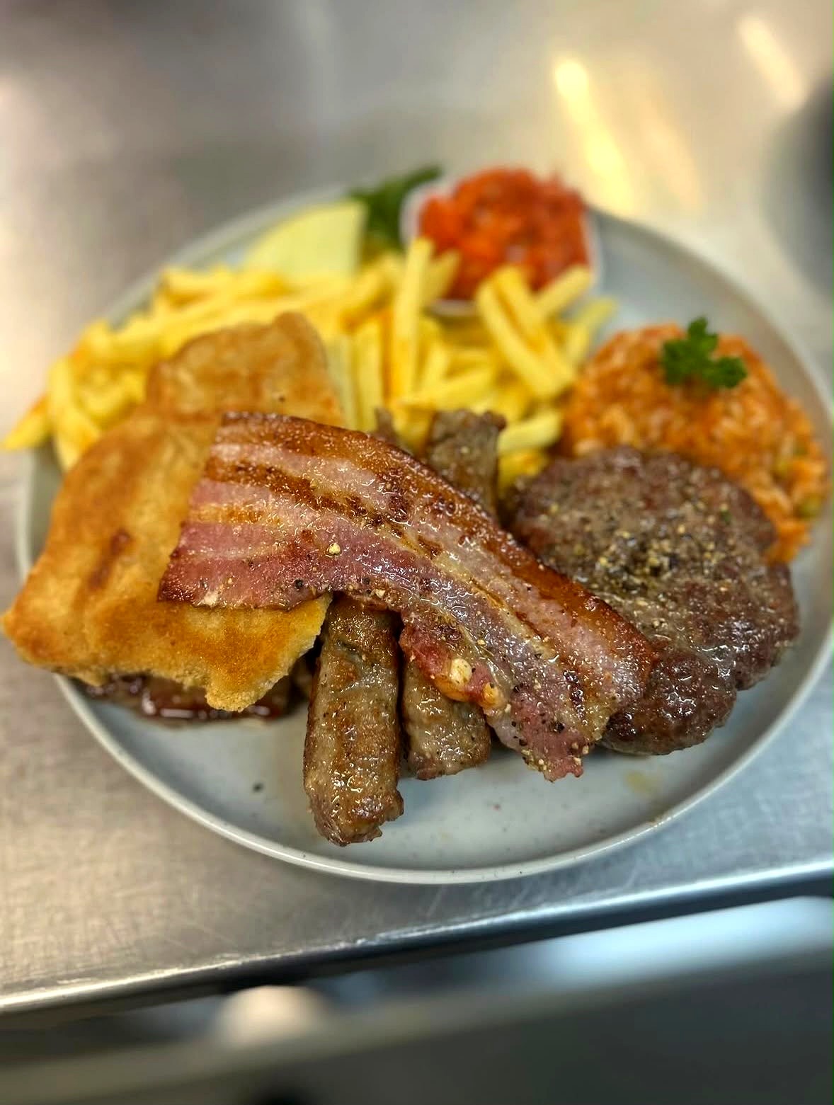 Gemischter Grillteller mit Schnitzel, Bauchspeck, Steak und Pommes frites